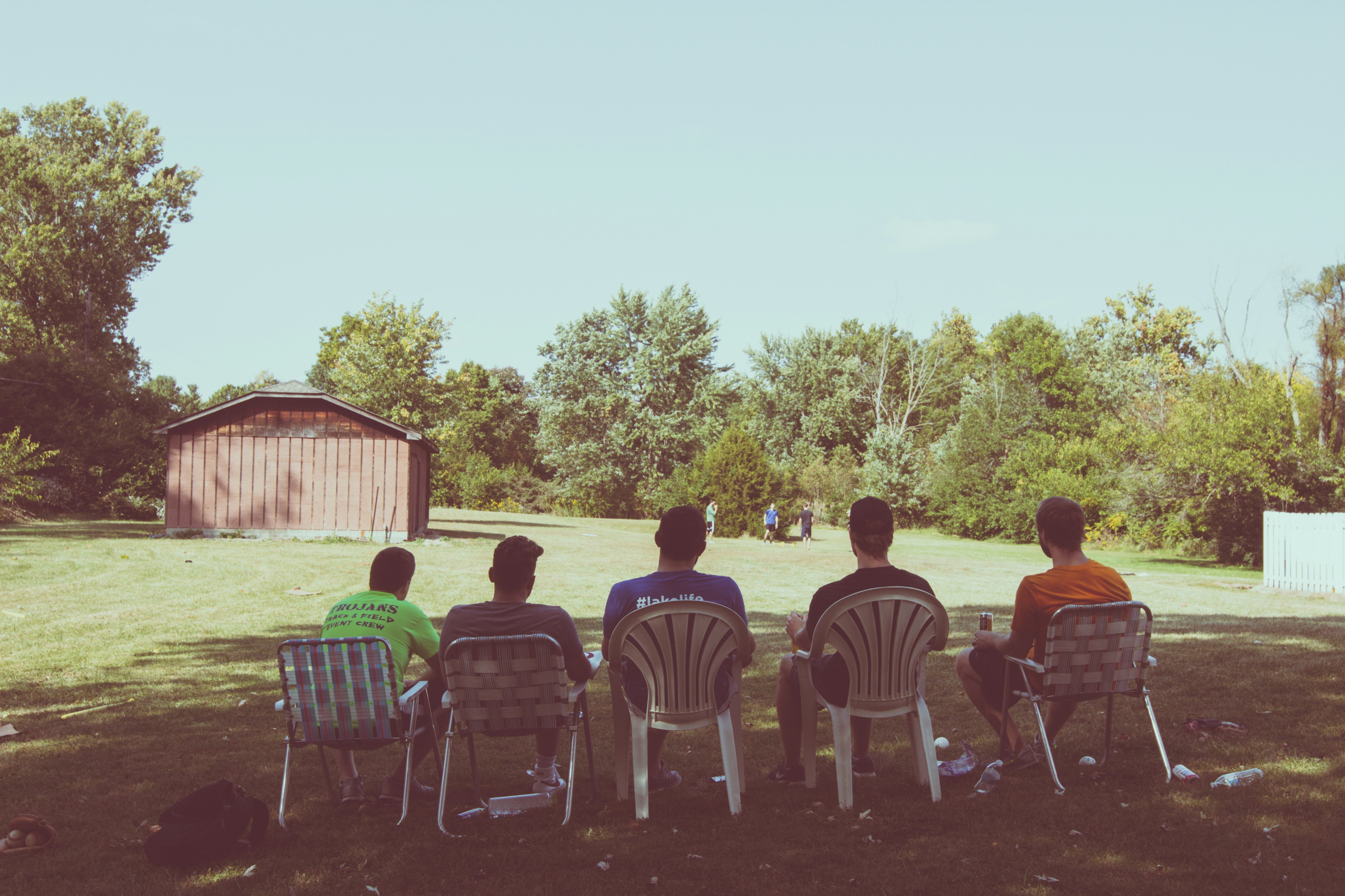 people sitting on white plastic chairs during daytime